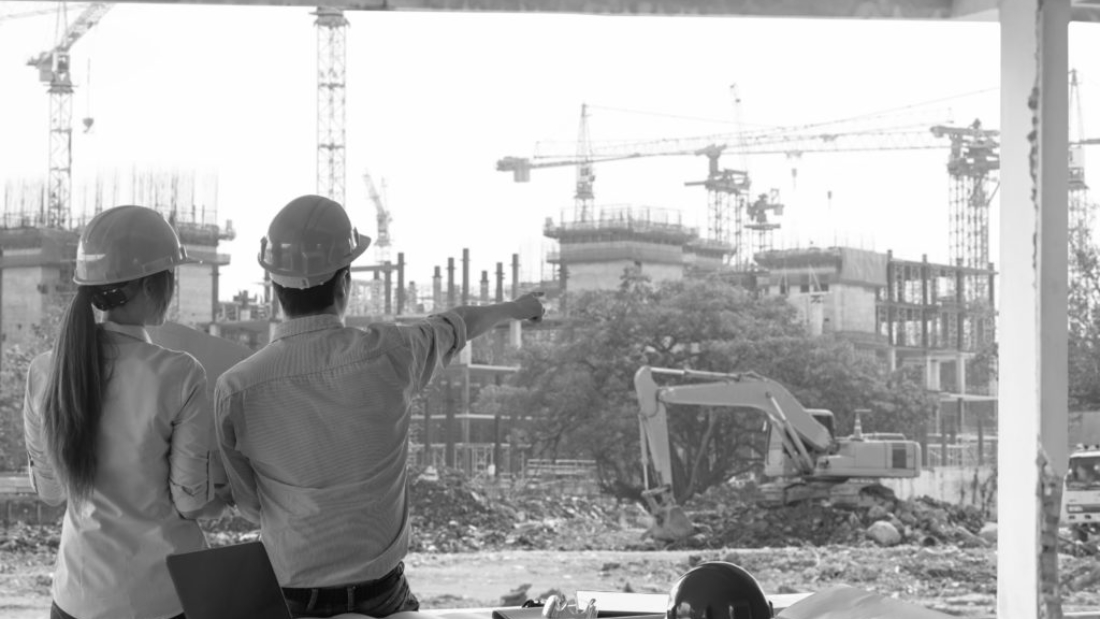 Engineer group and worker meeting, discussion with construction blueprint on site work and point finger to the work site