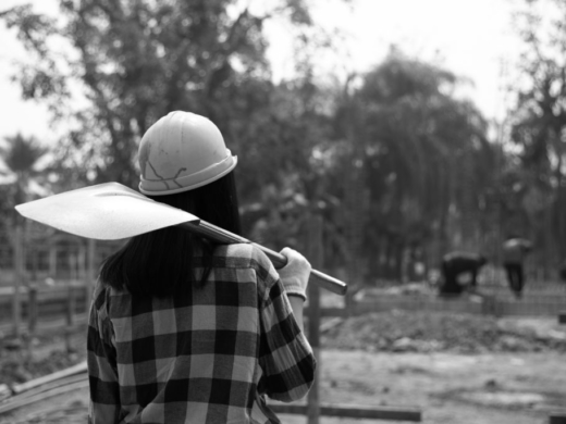 Construction workers carrying a shovel to the construction site